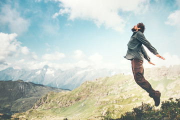 Happy Man jumping at mountains to clouds sky Lifestyle Travel emotional euphoria success concept adventure active vacations outdoor. - obrazy, fototapety, plakaty