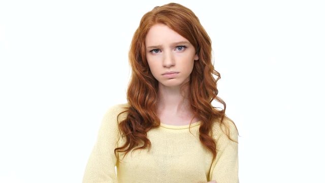 Upset stressed  young woman with red curly hair pointing finger at camera isolated over white 