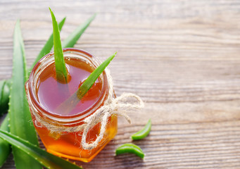 Honey in a glass jar and aloe vera on a wooden board. Alternative medicine