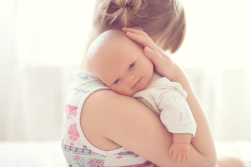 Girl kid cares about a doll, close-up, lifestyle