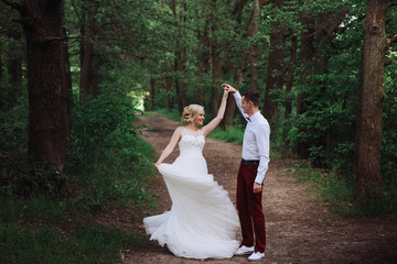 Happy and young bride and groom dancing on nature, dance pose on wedding day,wedding dance in the open air. Dancers love flying.