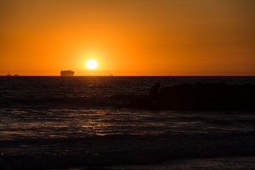 Sonnenuntergang am Strand von Kalifornien mit Frachtschiff