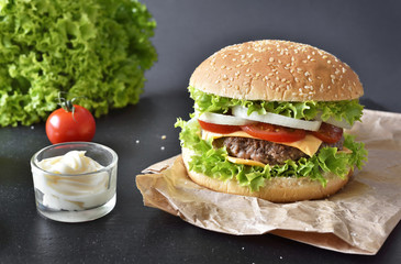 Fresh, delicious burger or cheeseburger with sauces and fresh ingredients. Hamburger on a slate plate.