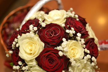 Basket with white and red roses and wedding rings
