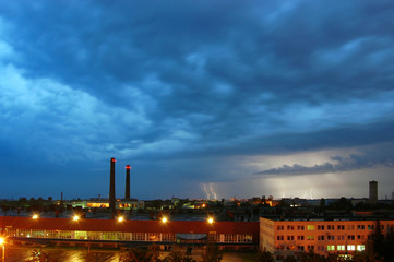 Aerial view of industrial plant at night during a thunderstorm with lightning.