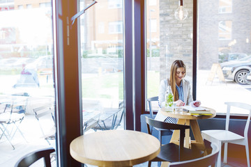 Beautiful Young Woman Sitting in Coffee Shop