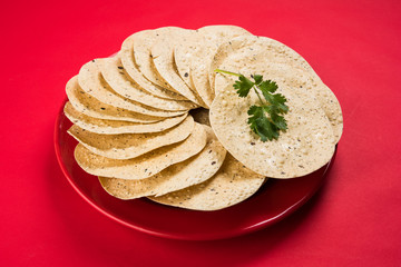 Indian snacks, deep fried or roasted crackers or papad. Mung dal and urad dal papad an Indian fried dish, which is an side dish for lunch and dinner. © StockImageFactory
