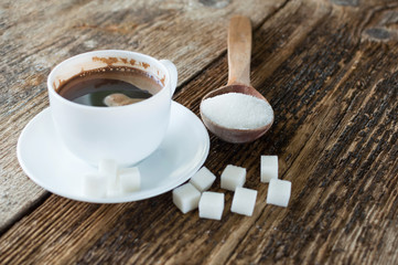 cup of coffee with milk and sugar spoon on the table