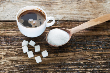 cup of coffee with milk and sugar spoon on the table