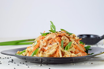 Korean traditional food. Raw chicken marinated with vegetables on a black plate on a white abstract background. easy cooking. Healthy food.
