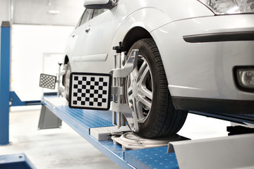 Grid sensor sets mechanic on auto. Car stand with sensors wheels for alignment camber check in workshop of Service station.