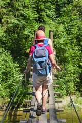 Wanderer überqueren einen Steg über einen Fluß