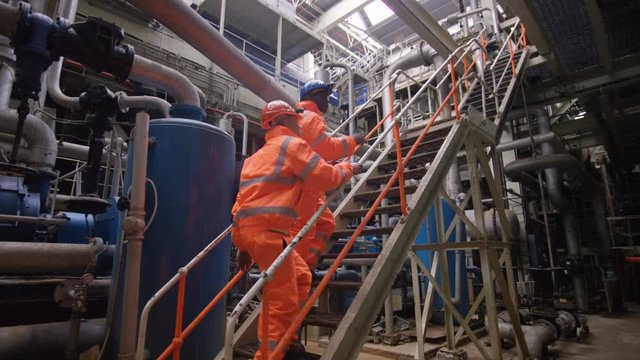  Engineers in the power industry walking through plant & discussing operations