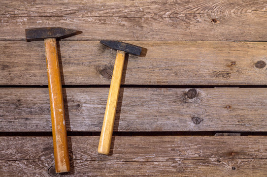 Two hammers, big and little on wooden background