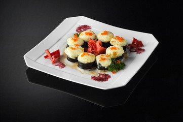 sushi in a white plate on a dark  background with reflection