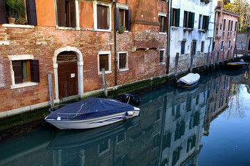 Fototapeta na wymiar Traditional evening in Venice. Boats along the houses.