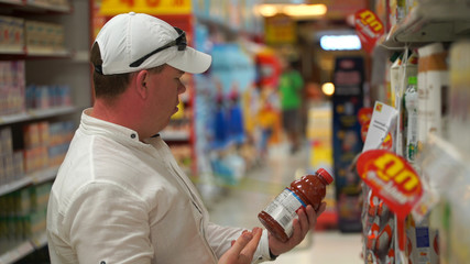man buys tomato juice in a supermarket