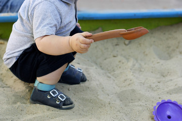 The kid plays with sand.