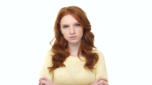 Angry aggressive girl with red hair standing with arms folded and saying I Hate You phrase over white