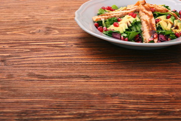 Salad with fried salmon, avocado and pomegranate seeds