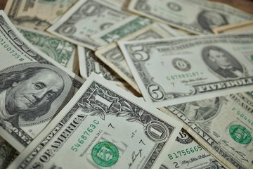 Financial background made of random heap of bank notes in the value of one, twenty and one hundred US Dollars in the accidental pile of money 