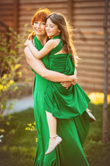 Little girl leans to her mother tender posing outside