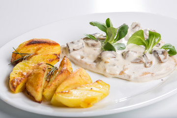 Tasty grilled chicken with mushroom sauce and baked potatoes