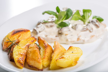 Tasty grilled chicken with mushroom sauce and baked potatoes