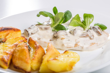 Tasty grilled chicken with mushroom sauce and baked potatoes