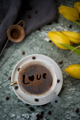 Black coffee on a table with flowers
