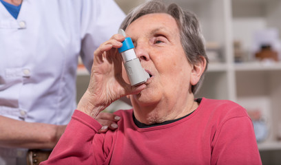 Senior woman with asthma inhaler - obrazy, fototapety, plakaty