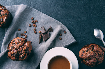 Chocolate muffins and coffee on a dark background