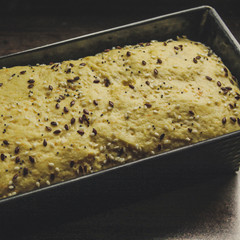  Dough in a rectangular shape for baking sprinkled with poppy seeds, sesame seeds, flax seeds