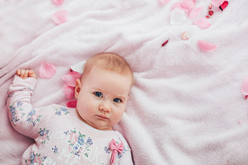 Adorable two month old baby girl lying on the pillow and looking into the camera
