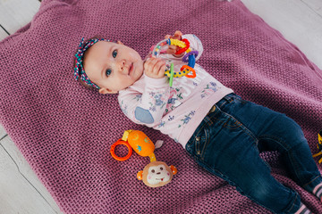 Adorable two month old baby girl lying on the pillow and looking into the camera