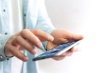 Hand holding black smartphone with operating system screen