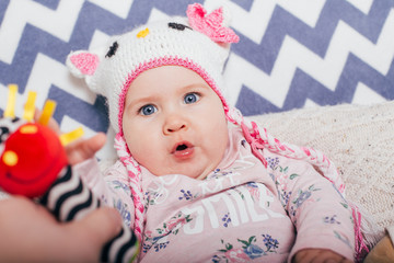 Adorable two month old baby girl lying on the pillow and looking into the camera