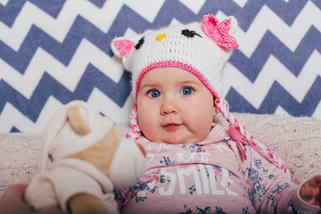 Adorable two month old baby girl lying on the pillow and looking into the camera