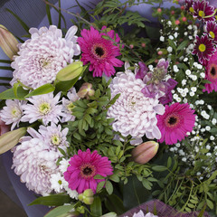 the Bouquet of chrysanthemums, gerberas, chamomiles in paper packing