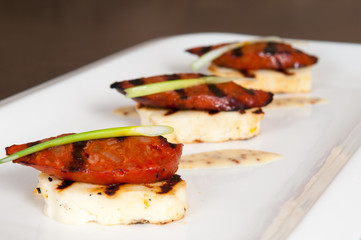 Halloumi cheese and grilled meat starter on white plate
