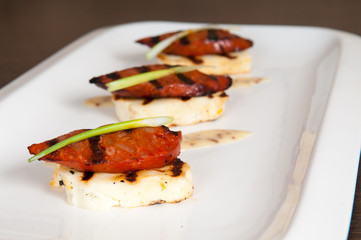Halloumi cheese and grilled meat starter on white plate