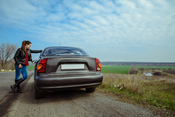 stylish woman stands near car on highway