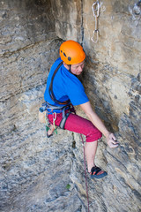 Climber in a helmet climbs up.