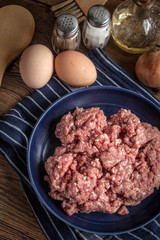 Minced meat on wooden background.
