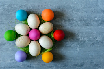Fototapeta na wymiar Top view of Easter eggs in a basket on grey concrete background in form of flower
