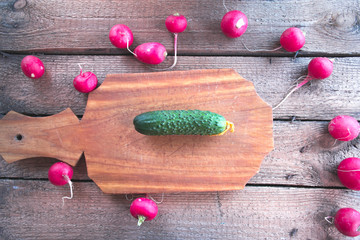 Still life of a cucumber radish on a wooden background.