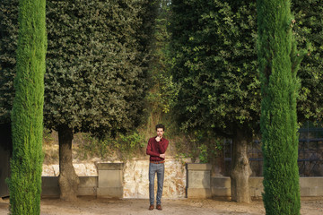 Fototapeta na wymiar Man posing among trees in park