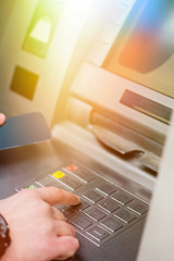 Hand of a man with a credit card, using an ATM. Man using an atm machine with his credit card.