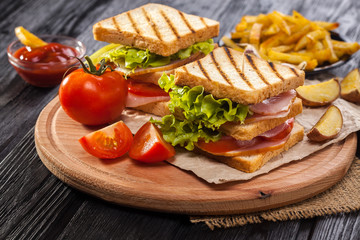 club sandwich with Tomato, lettuce, bacon, ham and french fries