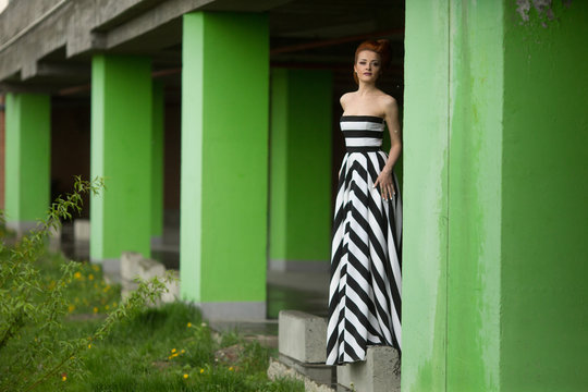 The elegance lady stands near coloums
